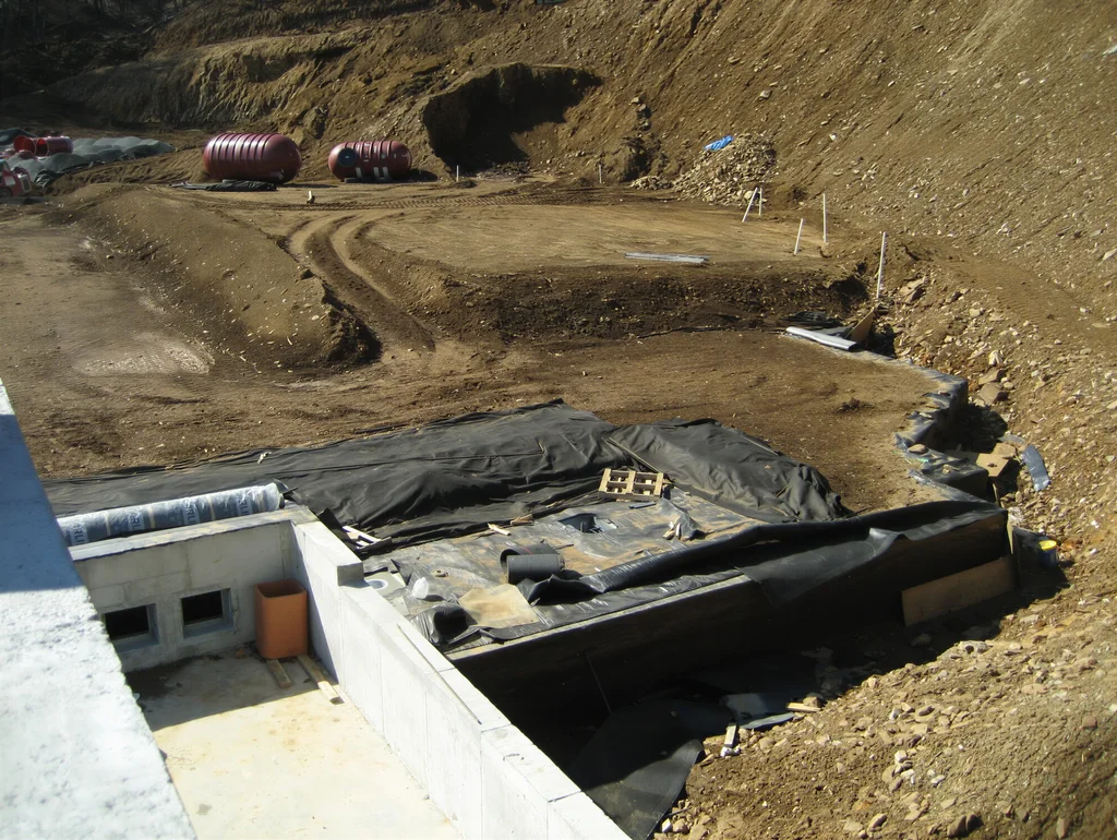Backfilling earth over a custom underground concrete shelter