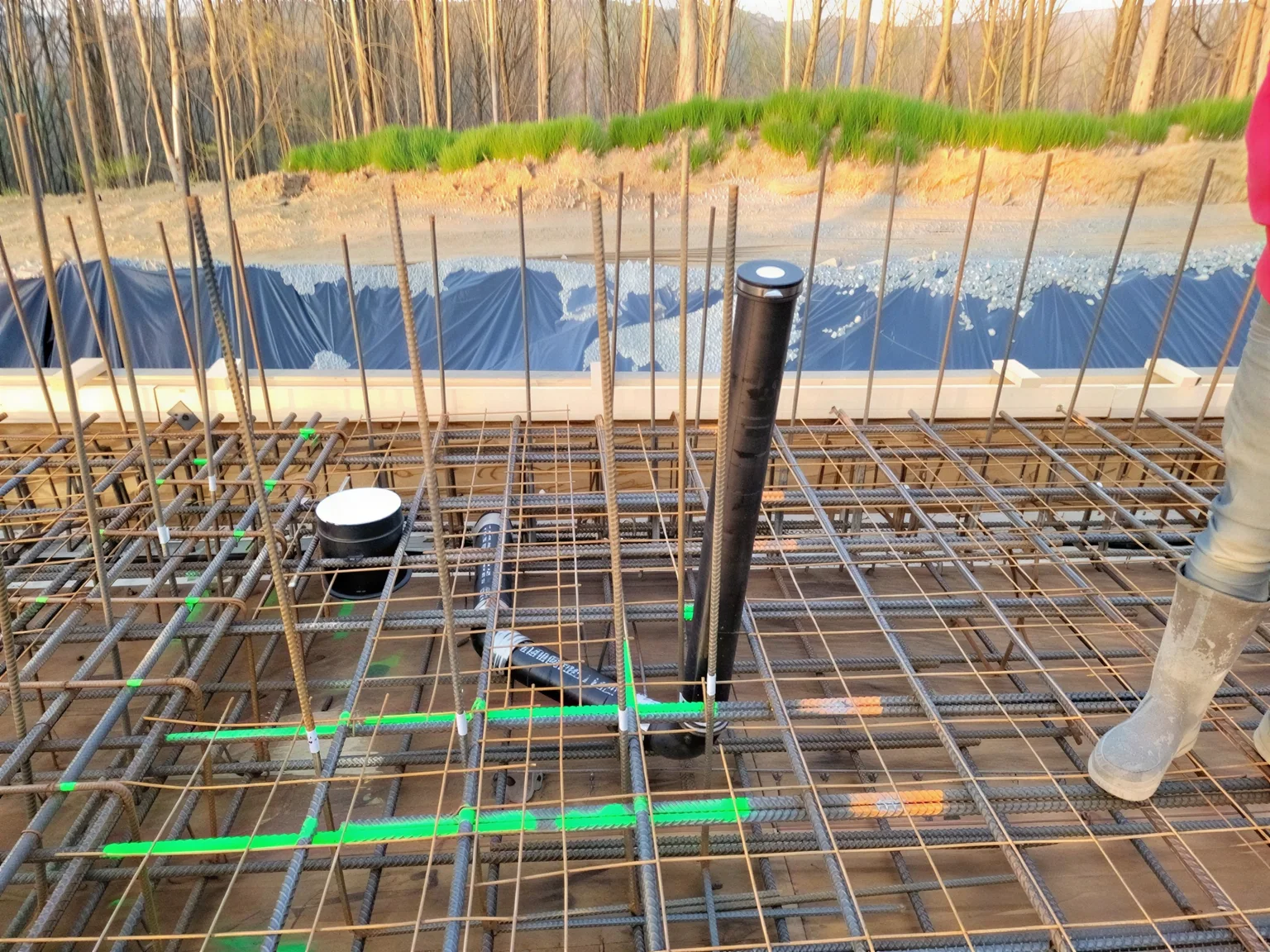 Detailed view of high-density rebar grid and service penetrations prior to concrete pour