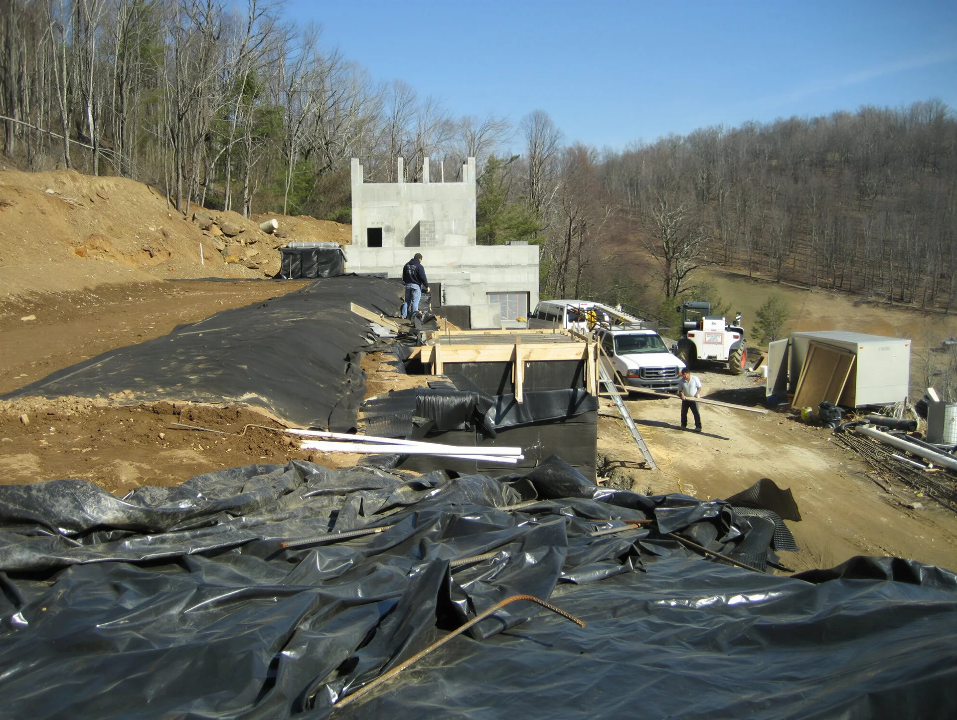 Reinforced concrete bunker structure being waterproofed and buried in a slope